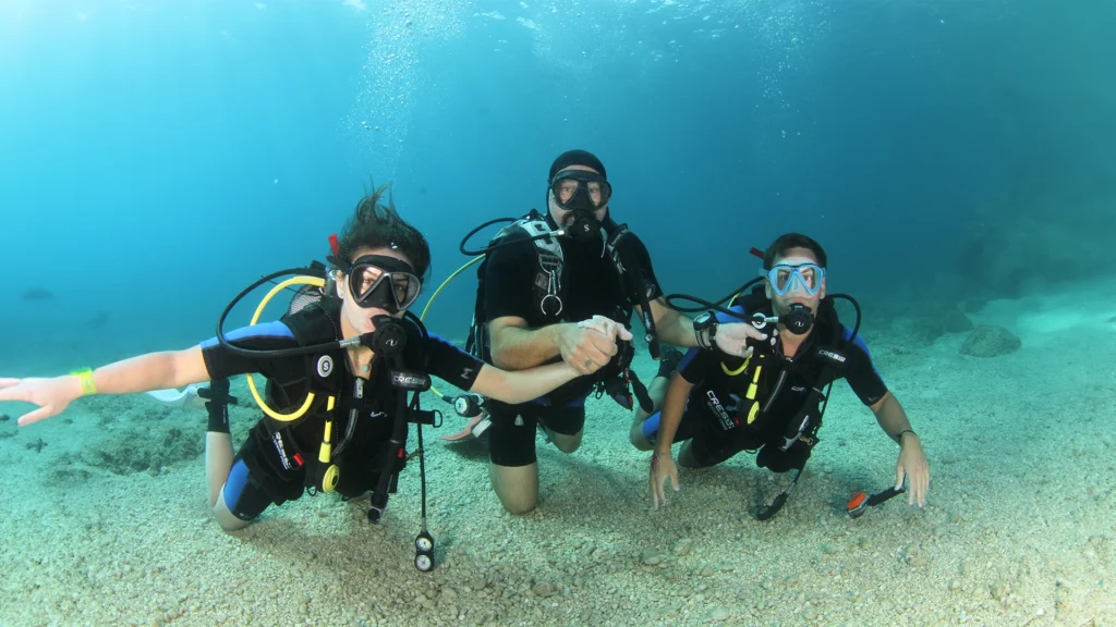 Basic Diver course. People with scuba diving suits in the bottom of the sea.