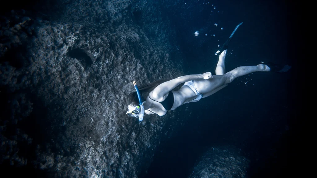 solo female diver being close to the bottom while on an aqua safari